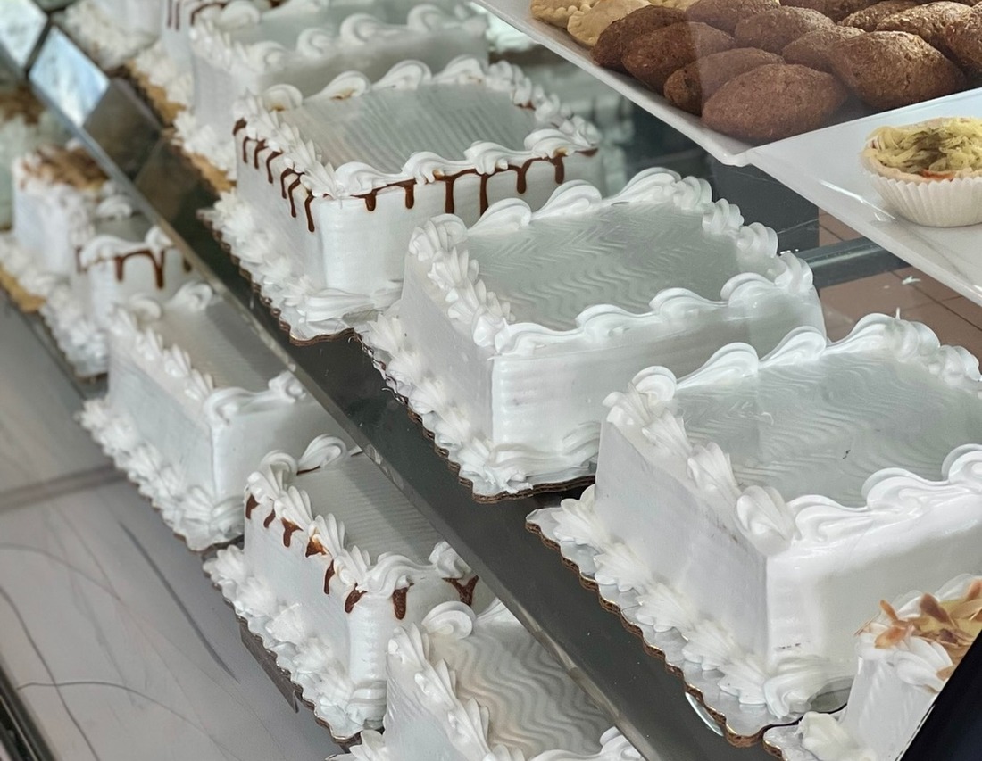 Bizcochos de crema blanca alineados en los estantes de la vitrina